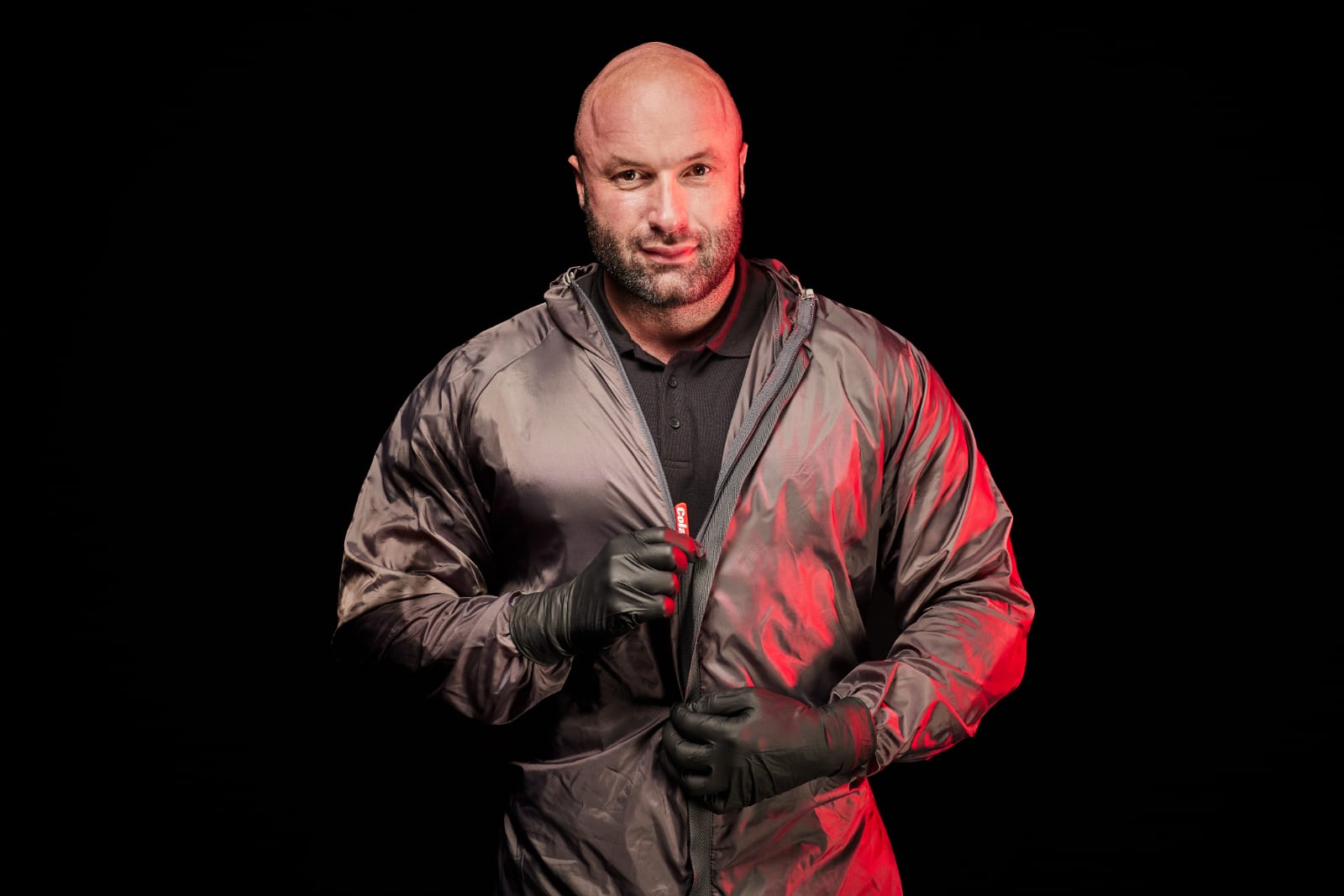 Alexander Rinas in schwarzer Jacke vor dunklem Hintergrund