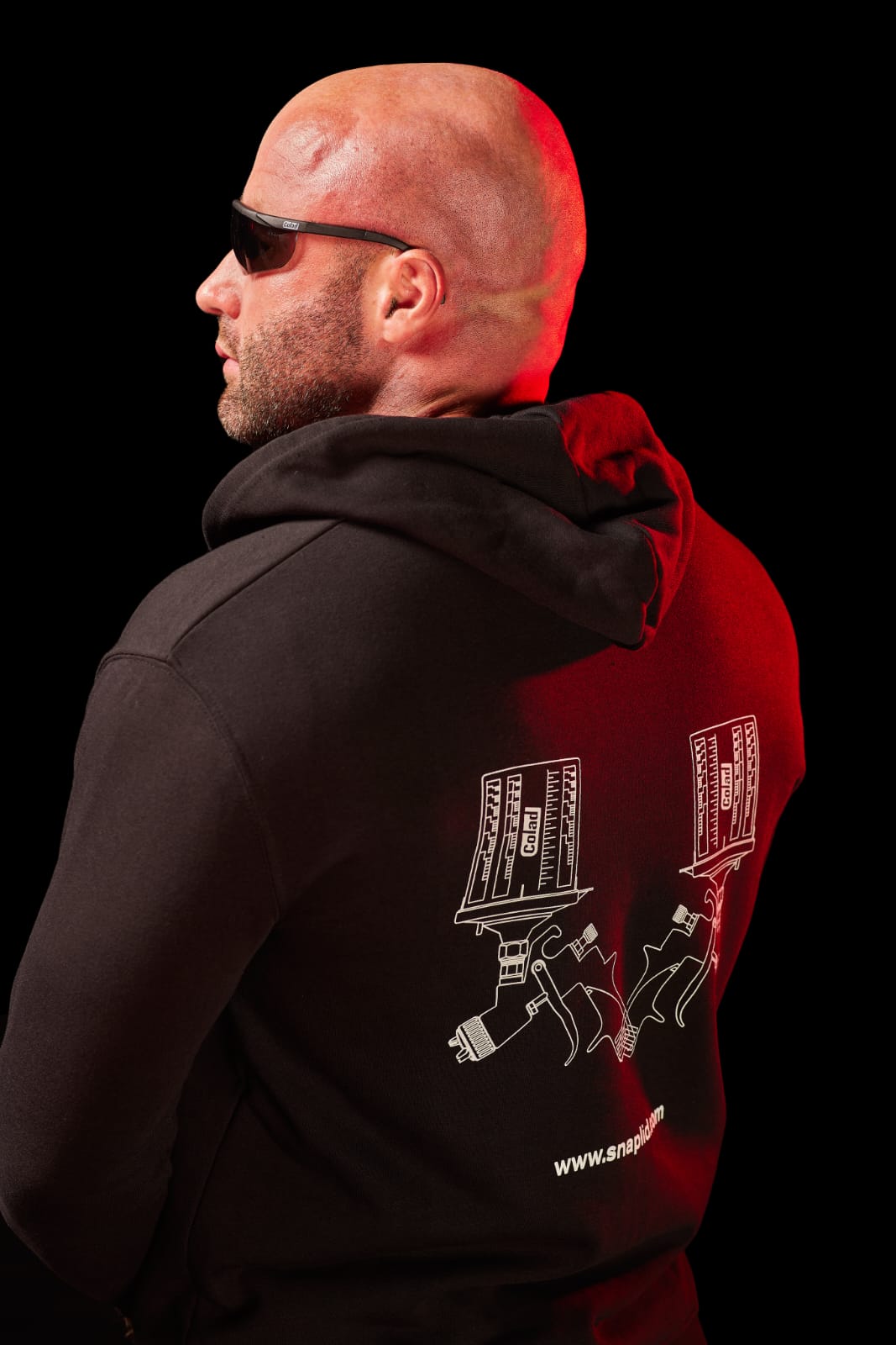 Alexander Rinas mit Sonnenbrille im roten Studiolicht